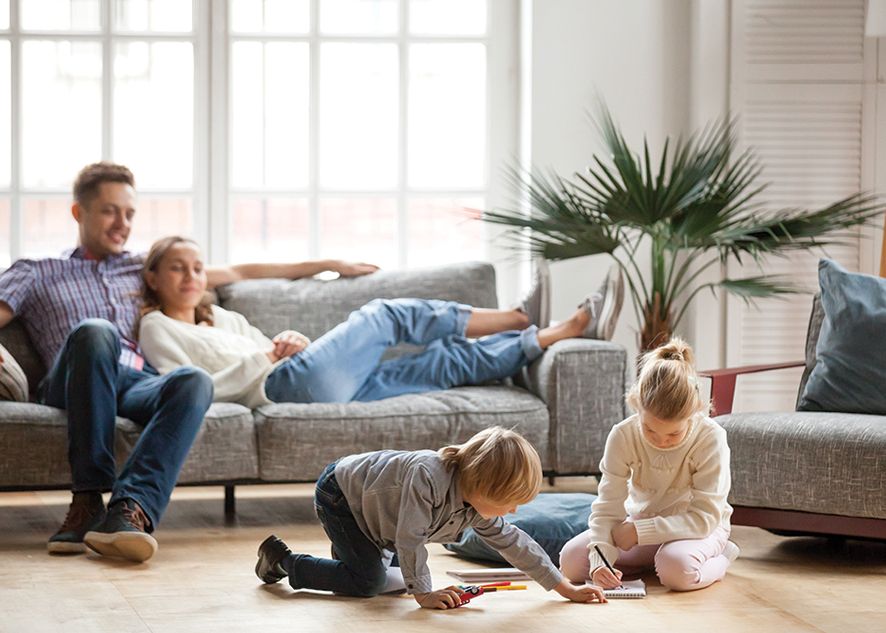 Husband, wife and their two kids relaxing in living room